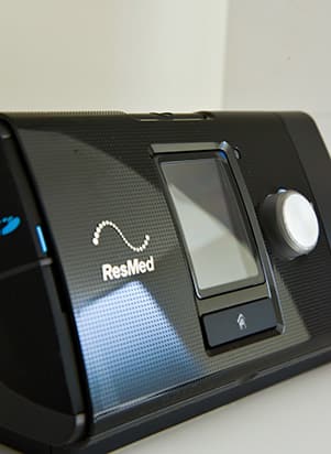 Detalhe da tela e do botão de um aparelho de CPAP da ResMed
